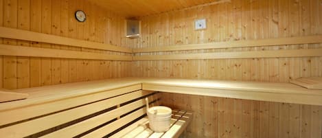 En sauna med træbænke og en spand.