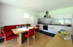 A modern kitchen with white cabinets, a microwave, and a coffee maker.