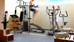 A gym with exercise equipment, a bench, and a window with a view. - Apartment Diedams [ground floor | 45 m²] - Apartments Susanne (Rehmen)