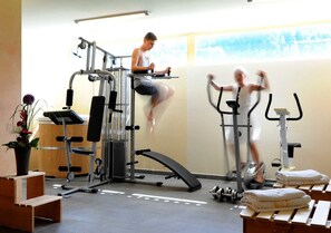 A gym with exercise equipment, a bench, and a window with a view. - Kanisfluh Apartment [first floor | 75 m²] - Susanne Apartments (Rehmen)