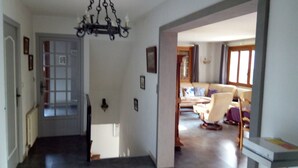 A hallway leading to a living room with a sofa and chairs. - Villa 130 m² near 3 valleys and spa (Salins-Les-Thermes)