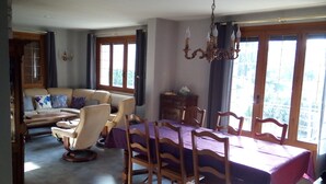 A dining area with a table set for six, surrounded by wooden chairs. - Villa 130 m² near 3 valleys and spa (Salins-Les-Thermes)