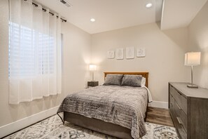 A bedroom with a bed, a nightstand, a dresser, and a window with sheer curtains. - Pure Luxury W Private Pool/Spa & Game Center! (Arvada)