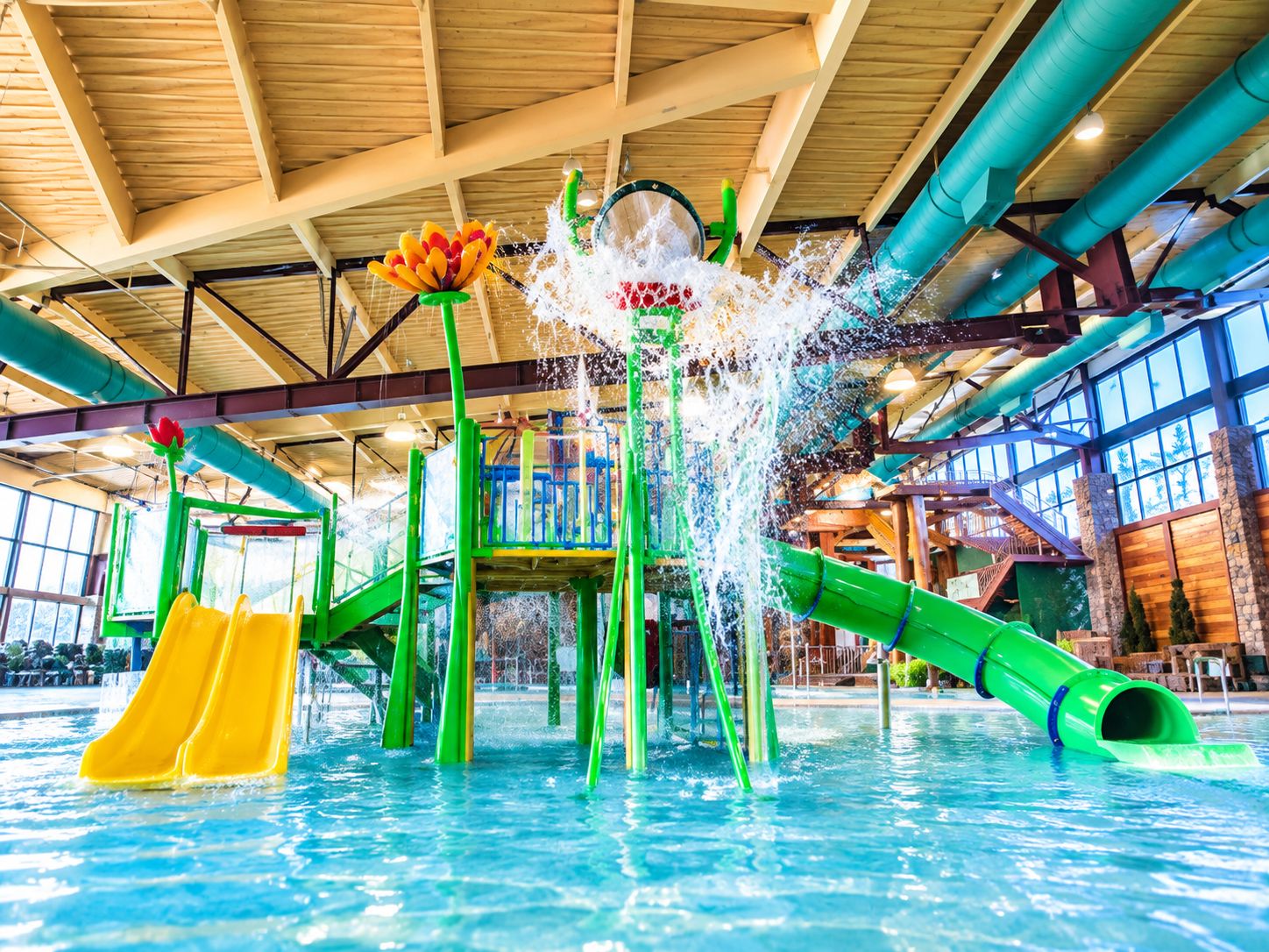 Ein großer, überdachter Wasserpark mit Rutschen und Wasserspielen.