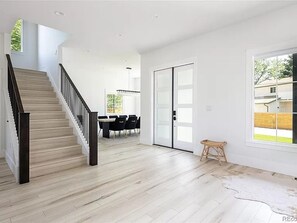 Stairs lead to an upper level, with a sliding glass door opening to an outdoor area.
