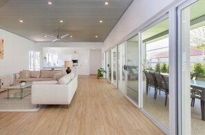 A spacious living area with a sofa, coffee table, and a ceiling fan. - Steps from the sea (Scarborough)