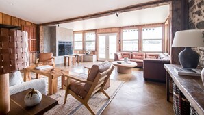 A spacious living room with a wooden floor, leather sofas, a coffee table, and a fireplace. - Grand Oaks Ranch · Pool·Spa · Game Barn · Animals (Fredericksburg)
