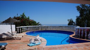 A swimming pool with a white balustrade, lounge chairs, and a decorative fish statue. - Spectacular villa with private pool and beautiful views (Nerja)