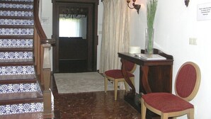 A staircase with blue and white patterned tiles, a wooden door, a desk with two chairs, and wall-mounted lamps. - Spectacular villa with private pool and beautiful views (Nerja)