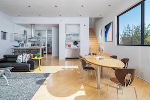 Um interior moderno com área de refeições, cozinha e sala de estar.