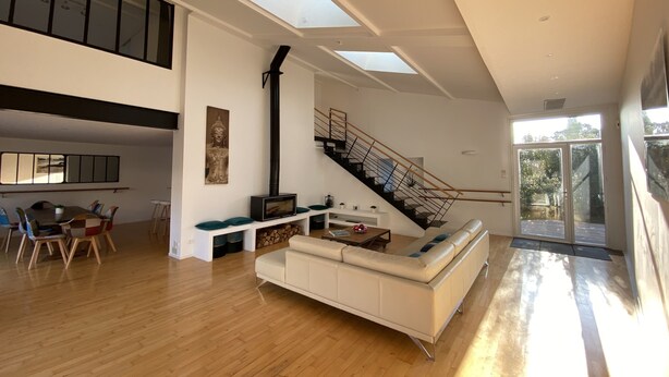 A spacious living area with a white sofa, wooden flooring, a staircase, and a skylight. - L'Arabesque, charming villa with private pool (Arradon)