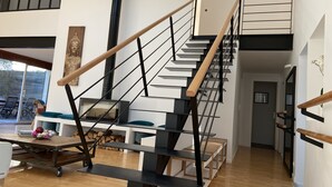 A modern staircase with wooden handrails and black metal railings, leading to a second floor. - L'Arabesque, charming villa with private pool (Arradon)