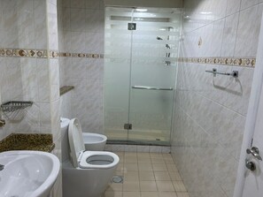 Een bad/douchecombinatie, een haardroger, een bidet, handdoeken