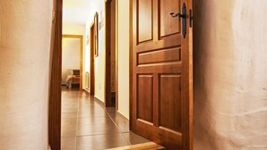 A hallway with wooden doors and a tiled floor.