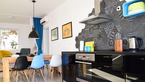Eine moderne Küche mit schwarzem Arbeitsplatz, Edelstahlgeräten und einer strukturierten Spritzschutzwand.