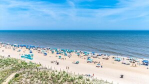 Uma praia com vários guarda-sóis e pessoas.