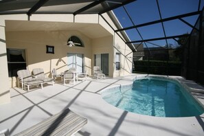 A covered outdoor swimming pool area with lounge chairs and a ceiling fan. - Cumbrian Retreat 4 Bedroom Home by RedAwning (Kissimmee)