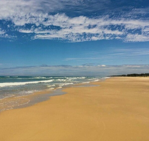 Enjoy a serene beach experience with gentle waves lapping at the shore.