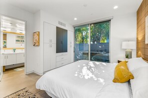 A bedroom with a bed, a wardrobe, and a bathroom.