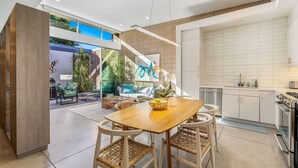 A modern kitchen with white cabinets, a stainless steel dishwasher, and a built-in oven. - Palm Desert Velo - Modern Condo w Spa (Palm Desert)