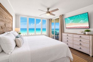 A bedroom with a bed, a ceiling fan, a TV, a dresser, and a view of the beach. - Gulfside 505 - Gulf Front, Community Pool, Hot Tub, Tennis, Basketball, Fitness! (Miramar Beach)