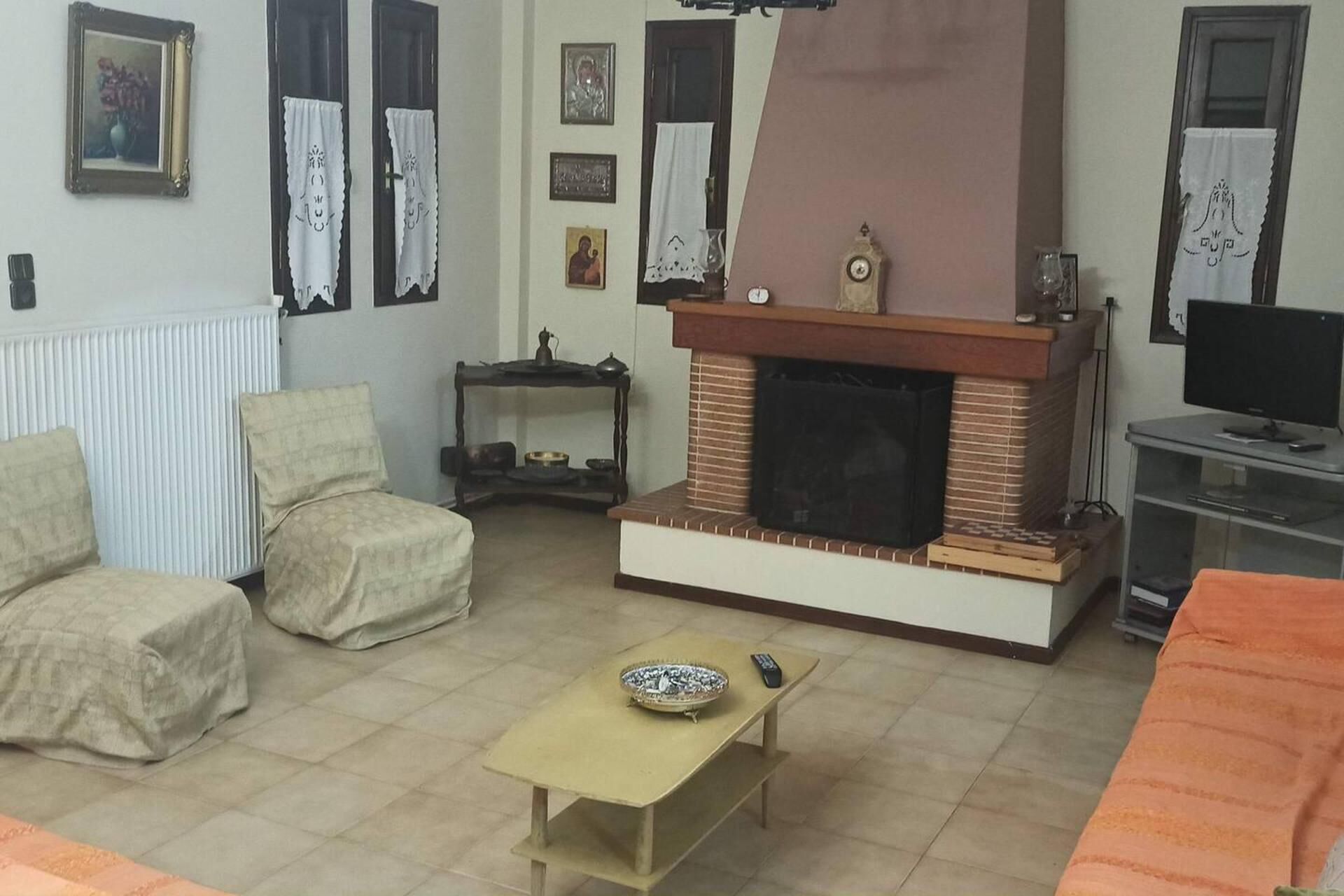 Un salon avec une cheminée, un téléviseur et un canapé.