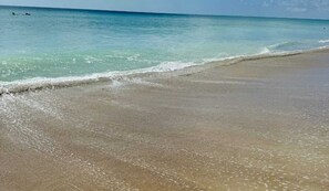 Una spiaggia con acque cristalline turchesi e una riva sabbiosa.
