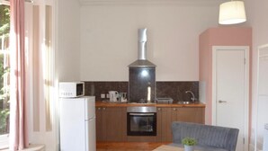 A compact kitchen with a microwave, oven, and a chimney. - Remarkable 1 Bed Apartment in Birmingham (Birmingham)