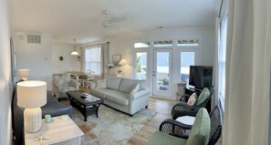 Relax in this inviting living space with a comfortable sofa, coffee table, and TV, perfect for unwinding and socializing.