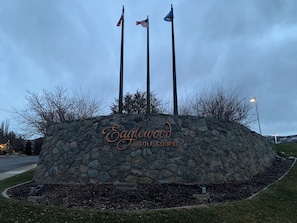 Eine Steinmauer mit der Aufschrift „Eaglewood Golf Course“ und drei Flaggen.