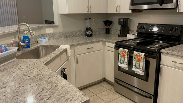 Enjoy cooking in this well-equipped kitchen with a sink, stove, dishwasher, coffee maker, and blender.