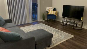 Relax in this stylish living room with a comfortable sofa, large TV, and a beautiful view.