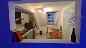 Una cocina compacta con comedor, una ventana y una pequeña planta.