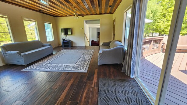 A spacious living area with two sofas, a large rug, and a wooden ceiling. - Sleeps 18!  Heated pool and lake access. (Mears)