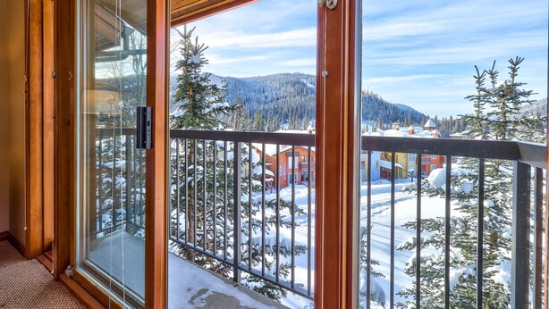 Ein Balkon mit Blick auf eine verschneite Landschaft und einen Berg.