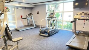 Un gimnasio con cintas de correr, una bicicleta estática y máquinas de pesas.