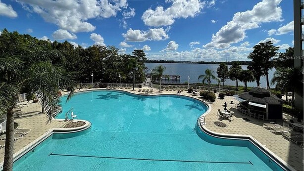 Una piscina con vista a un lago y un cielo despejado.
