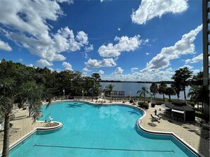 En swimmingpool med udsigt til en sø og en blå himmel.