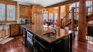 A spacious kitchen with wooden cabinets, a granite countertop, and a stainless steel sink. - Luxurious Mountain Retreat - Minutes from Park City and Deer Valley (Coalville)