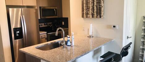 Kitchen area with bar stools and all major appliances
