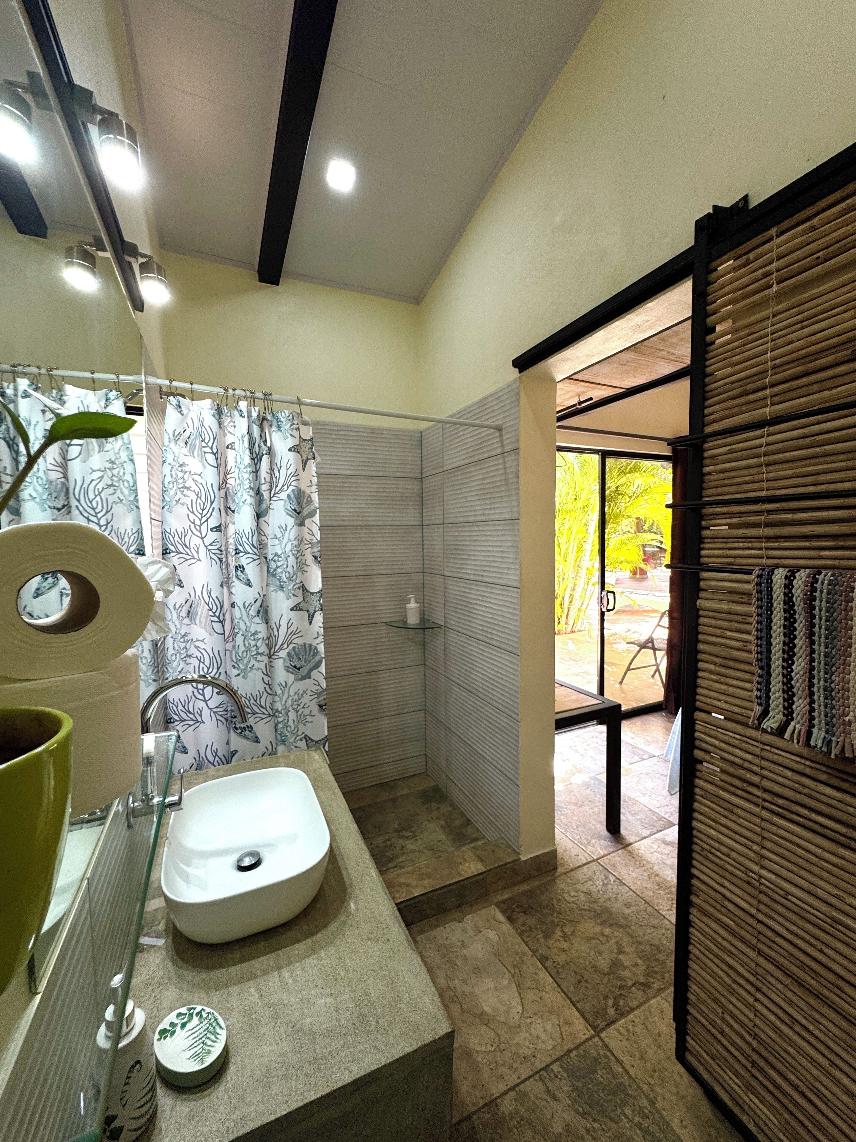A bathroom with a sink, toilet, and shower area.
