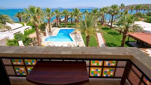 A pool with a clear view of the ocean, surrounded by palm trees and a well-maintained lawn. - My Marina Select Hotel (Datça)