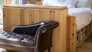 A wooden cabin bedroom with a bed, a leather sofa, and a wooden desk. - Cooper Bay Lakeside Escape – 322ft frontage, quiet, stunning west views! (Bracebridge)