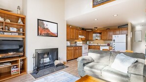 A living room with a fireplace, a sofa, a coffee table, and a bookshelf. - Indoor Pool, steps from beach  JL304 (Birch Bay)