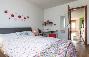 Cozy retreat with a large bed, desk, and mirror.