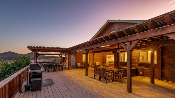 A wooden deck with a grill, outdoor seating, and a view of the mountains. - 🌅 Sunset Ranch 🌅 Views Views Views with Private Indoor Pickelball Court (Flagstaff)