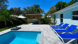 A swimming pool with lounge chairs, a pergola, and a patio area. - Mystical - Relaxing Heated Pool and Stylish Comfortable Home, Pet Friendly! (St. Augustine)