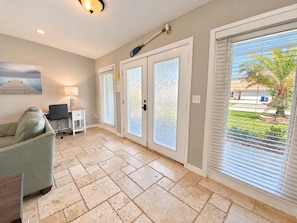 A room with a sofa, a desk, and a door with frosted glass panels.
