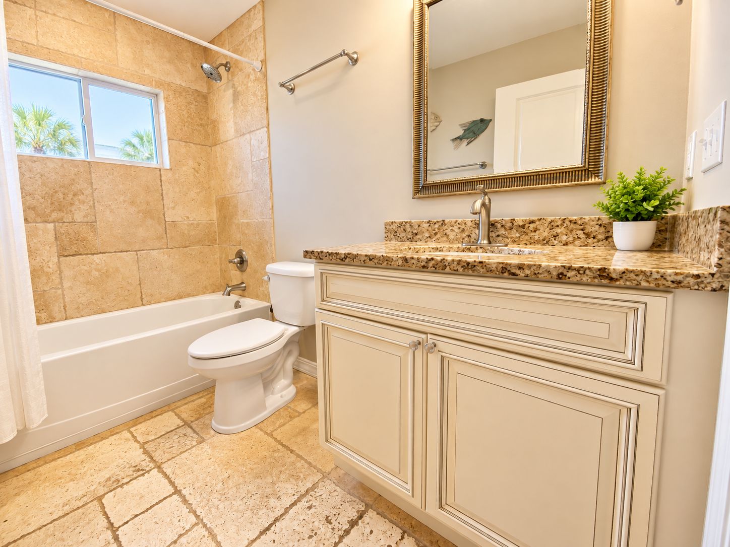 A bathroom with a bathtub, toilet, vanity with drawers, a sink, and a mirror.