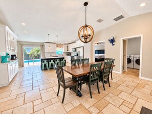 A spacious kitchen with a dining area, a view of the pool, and a laundry room.